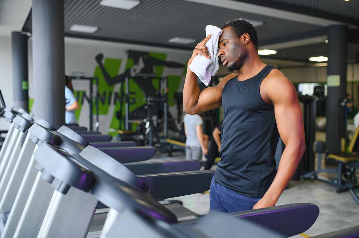 adult male working out on a treadmill in a gym