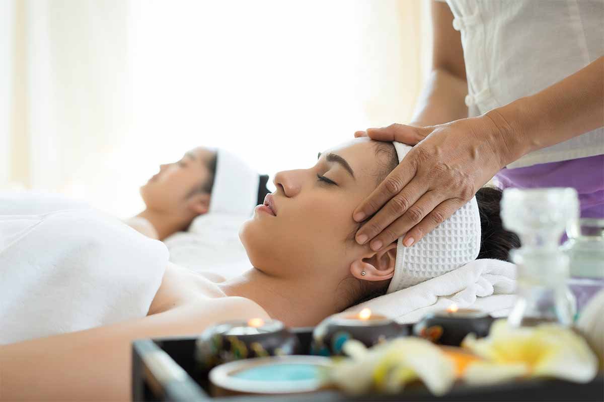 young beautiful woman having face massage enjoying spa day